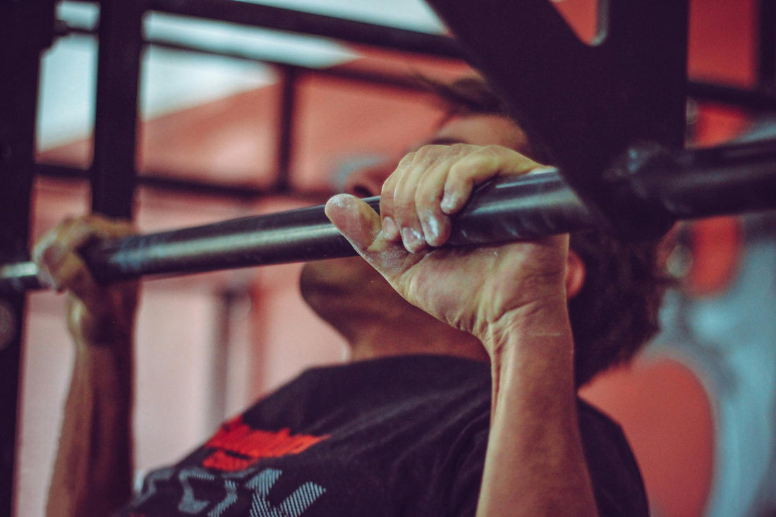Beginnende sporter voert een pull-up uit in een thuisomgeving als onderdeel van een krachttraining workout zonder apparatuur.