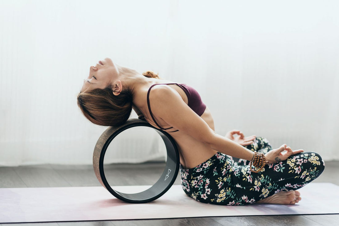 Yoga wheel in gebruik bij rug stretch – ideaal bij spanning in rug en borst.